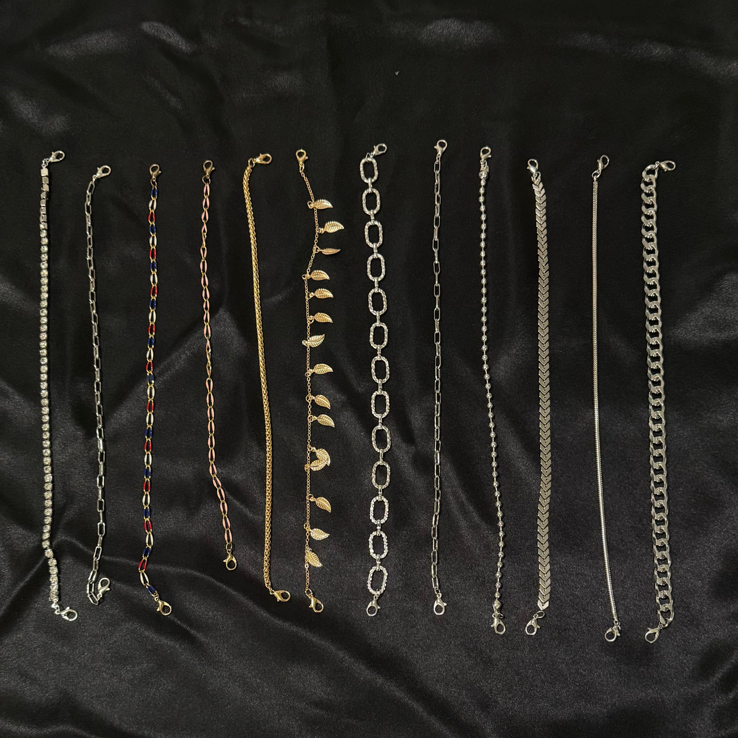 Set of various chain necklaces on a black fabric background