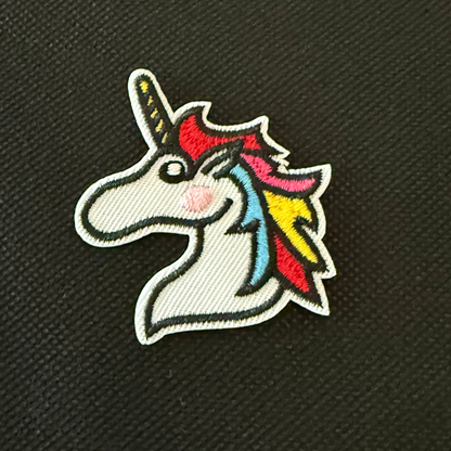 Colorful unicorn patch on a black textured background