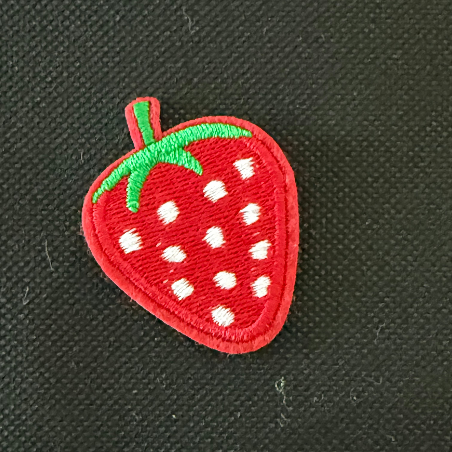 Embroidered strawberry patch on a black background