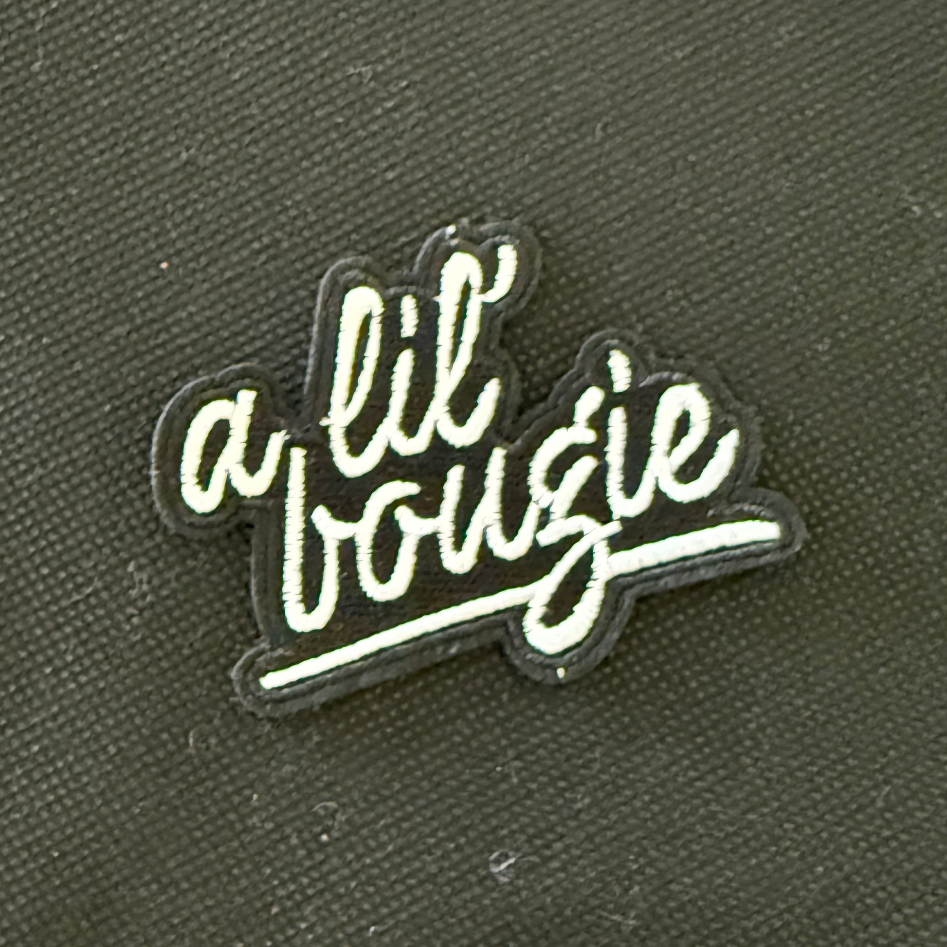 Embroidered patch with 'a lil bougie' text on a dark background