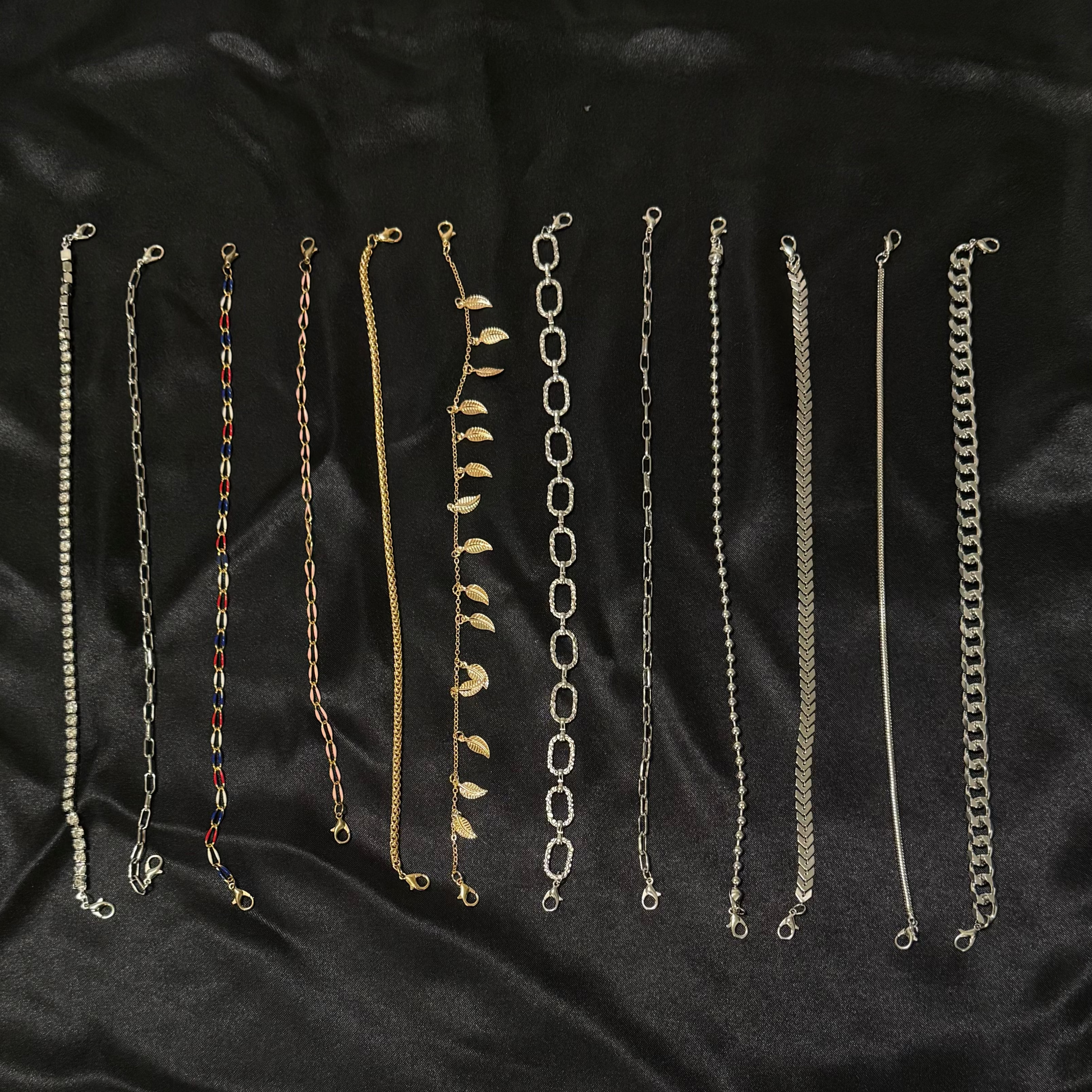 Set of various chain necklaces on a black fabric background
