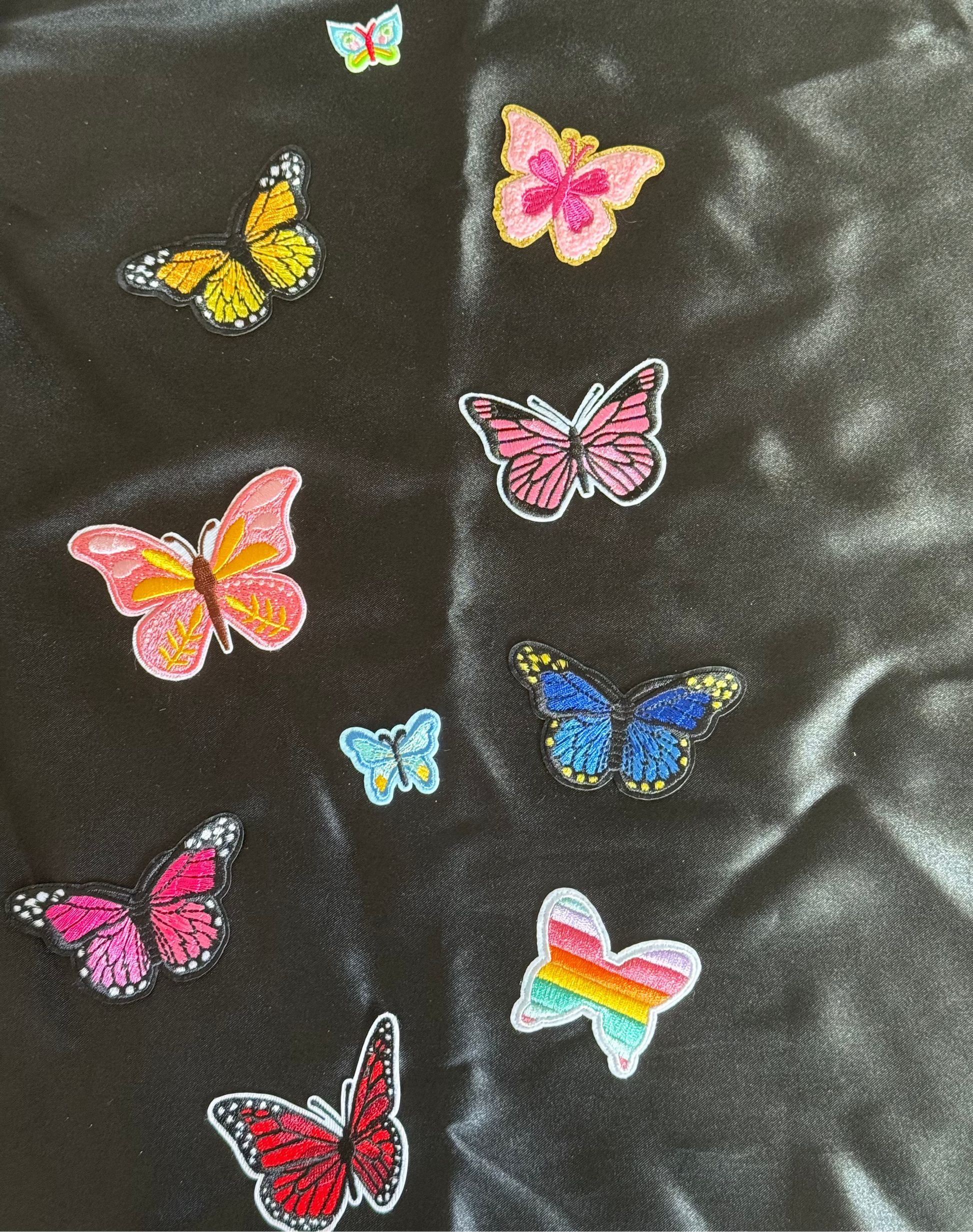 Colorful butterfly patches on a black satin background