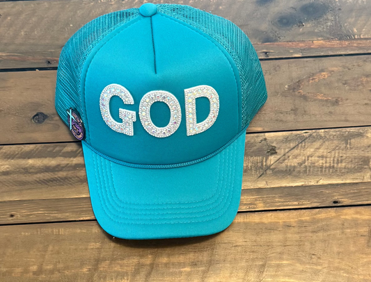 Blue cap with 'GOD' White rhinestone letter patches on it against a wooden background
