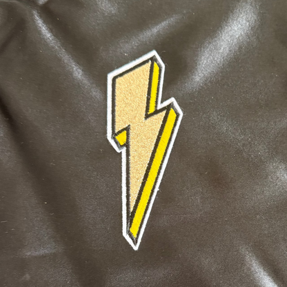 Yellow lightning bolt patch on a black fabric background