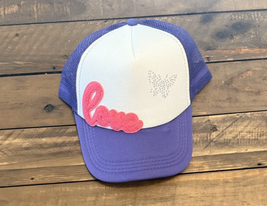 purple and white hat with a pink Love patch and a Rhinestone Butterfly. pic taken on a wooden background
