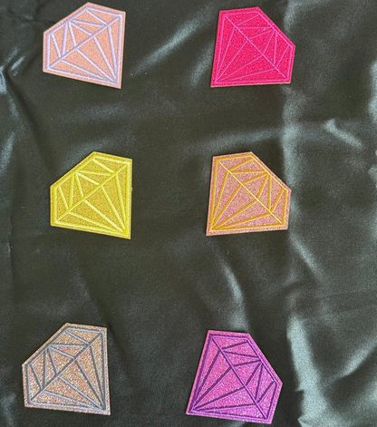 Geometric diamond-shaped patches in various colors on a dark fabric background